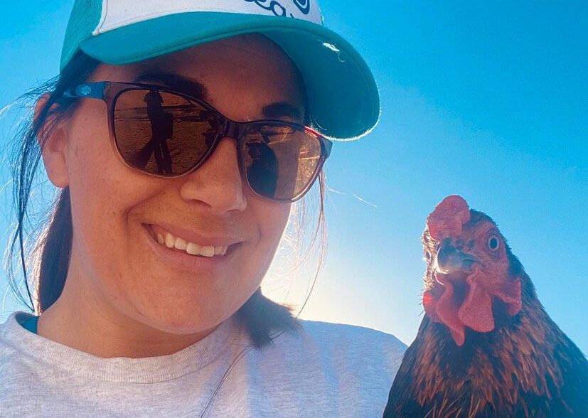 chelsey smiling beside a chicken